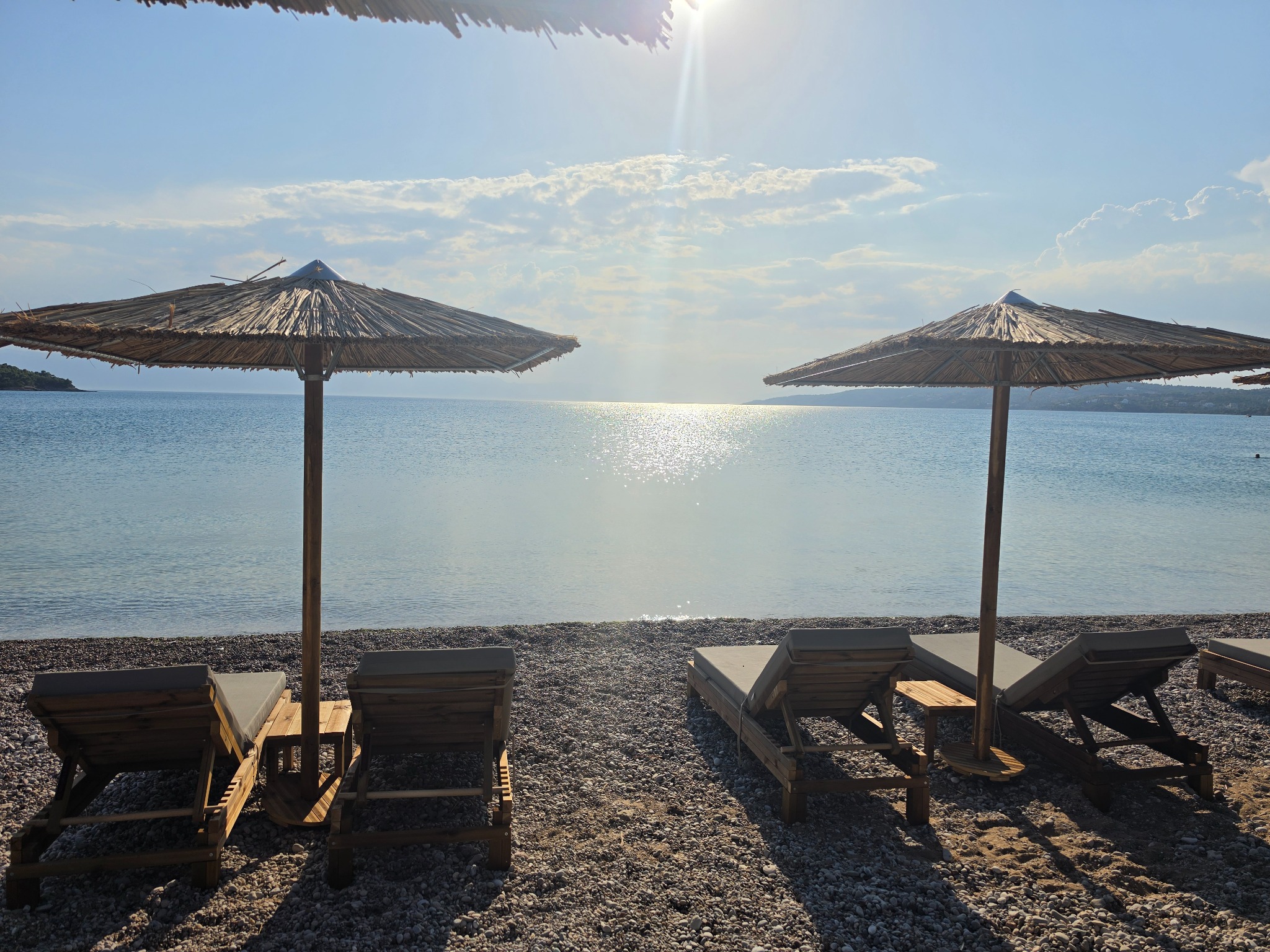Sunbeds beside calm water